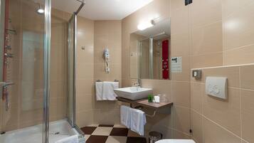Ein modernes Badezimmer mit Duschkabine aus Glas, Waschbecken und Toilette.