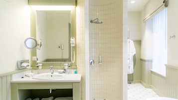 Un baño con lavamanos, espejo y ducha.