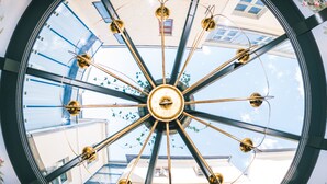 A large, circular skylight with a central hub and radiating beams, allowing natural light to enter a building. -  Antonius Boutique Hotel (Tartu)