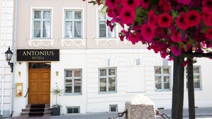 The exterior of the Antonius Hotel with a wooden double door, white-framed windows, and a sign above the entrance. -  Antonius Boutique Hotel (Tartu)