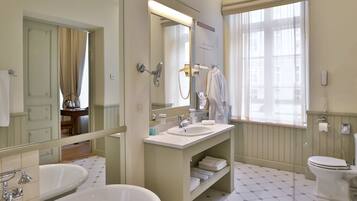 Une salle de bain avec une baignoire, un lavabo, des toilettes et un grand miroir.