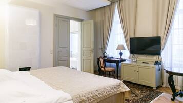 Una habitación de hotel con una cama, un escritorio, un televisor y un armario.
