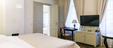 A hotel room with a bed, a desk, a television, and a cabinet.