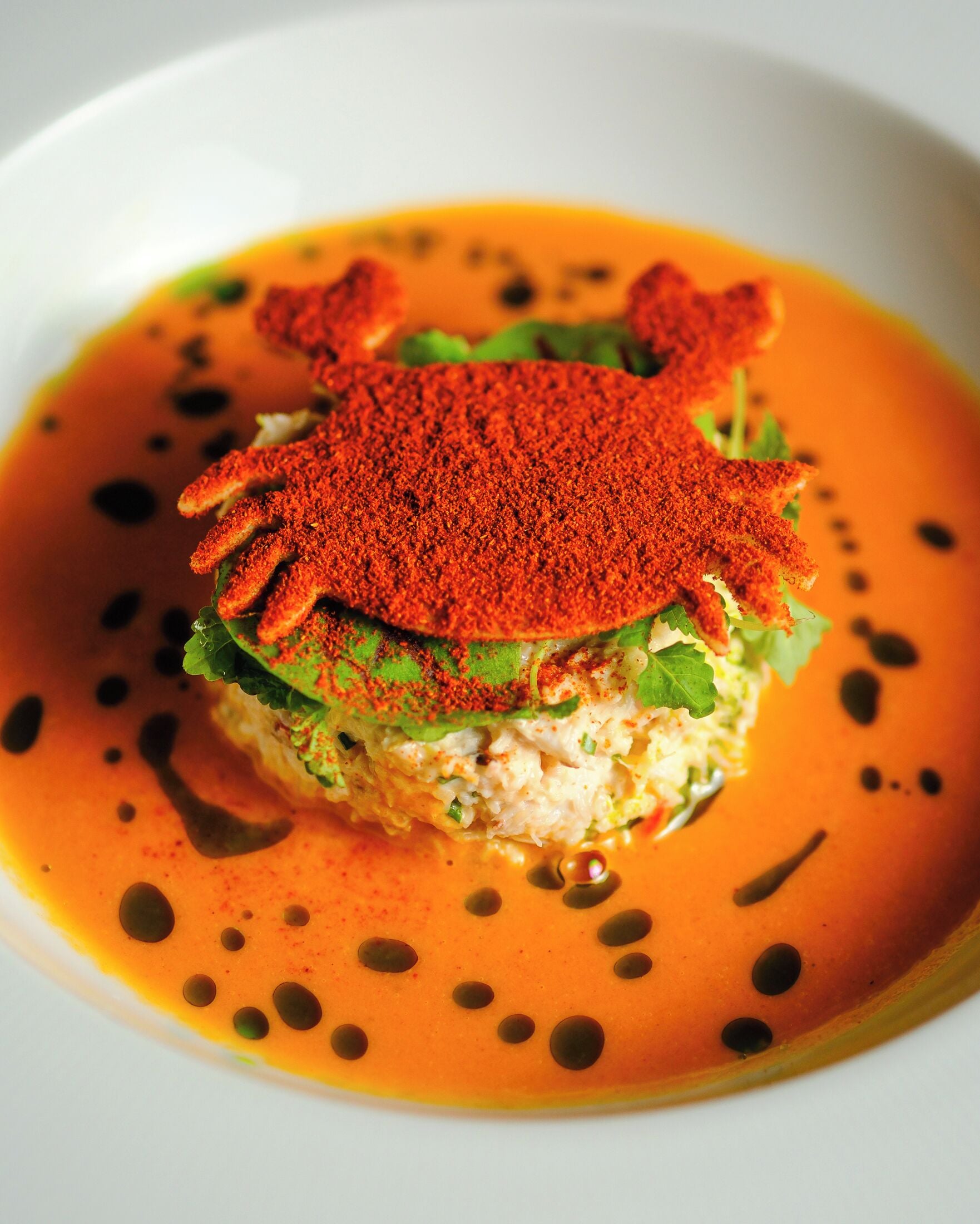Un plato con una salsa naranja vibrante y un toque de especias rojas.