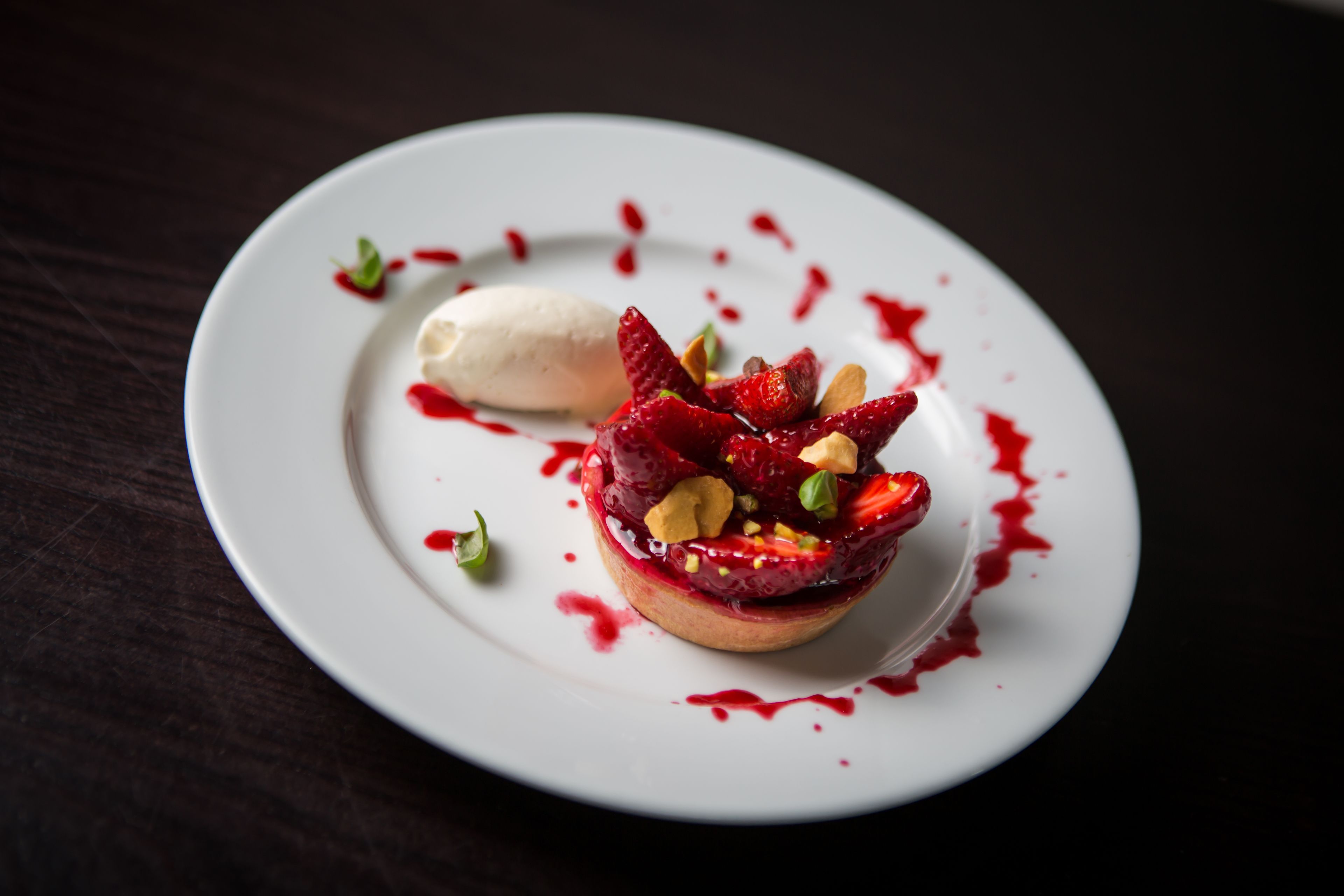 A dessert on a white plate with a dark background.