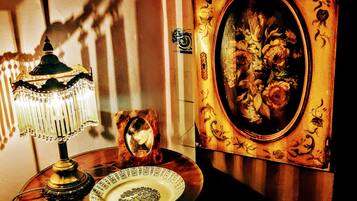 A table with a table lamp, a framed mirror, and a plate with a floral design.