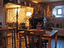 Un interior rústico con paredes de piedra, muebles de madera y una chimenea.