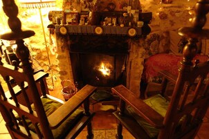 Una habitación acogedora con chimenea, muebles de madera y una estantería a cuadros.