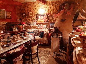 Ein gemütlicher, rustikaler Raum mit Essbereich, Tisch gedeckt mit Tellern und Blumenvase.