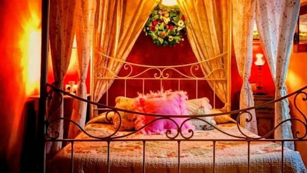 Une pièce confortable avec un lit, des rideaux et une décoration florale.