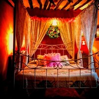 Una habitación acogedora con cama, cortinas y una decoración floral.