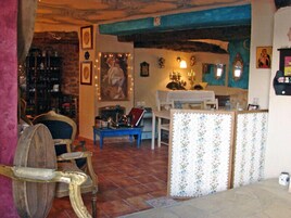 Una sala de estar acogedora con un estilo rústico, que incluye una silla de madera, una mesa azul y un separador con diseño.