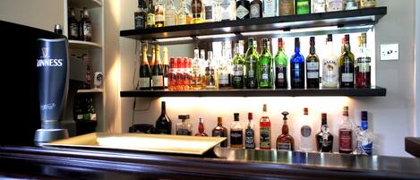 A bar area with shelves stocked with various liquor bottles.