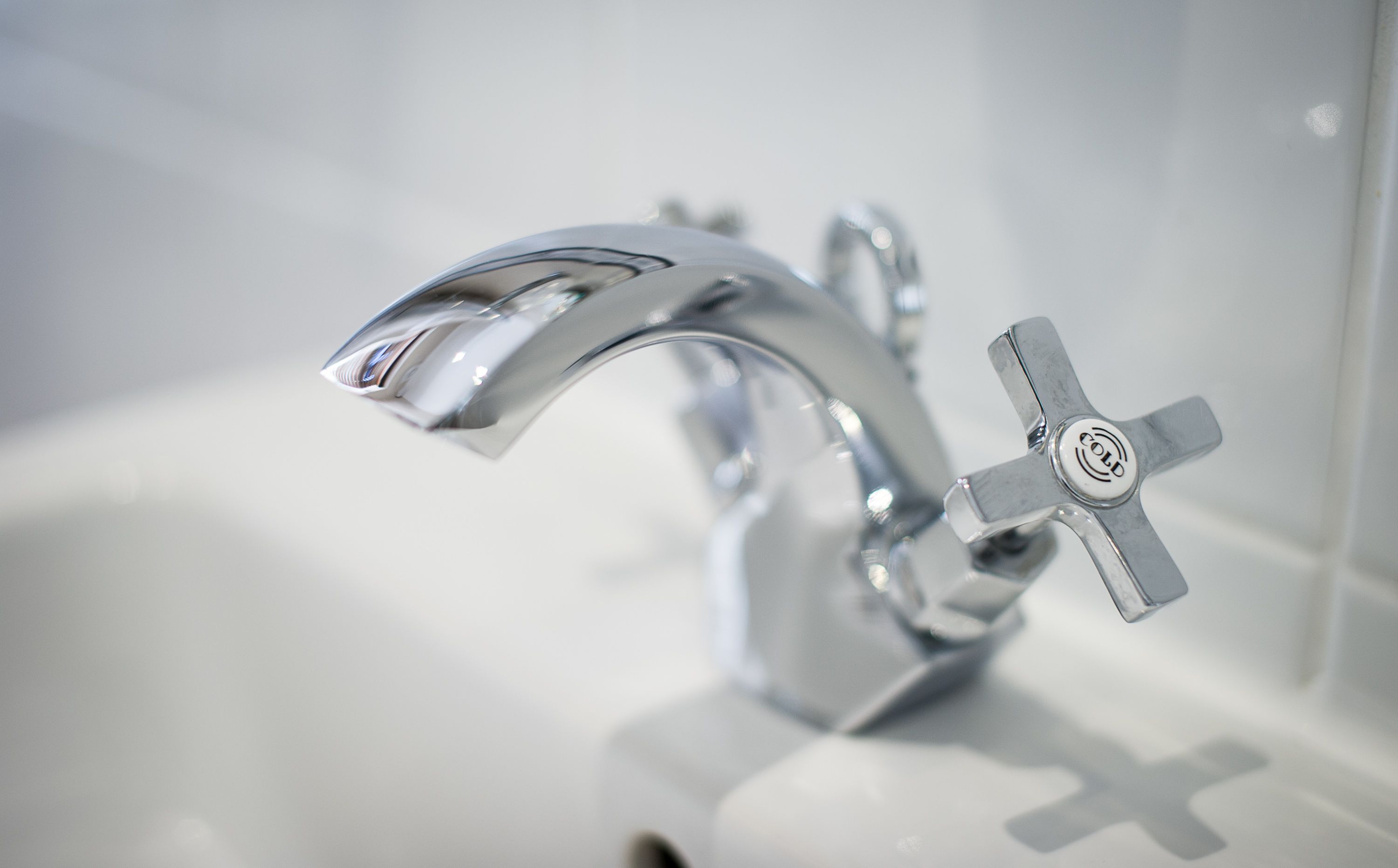 Un baño moderno con grifo cromado y dispensador de jabón.