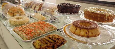 A buffet with various desserts and pastries displayed on glass trays.