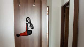 A wooden wardrobe with a mirror, a hanging shoe rack, and a small shelf.