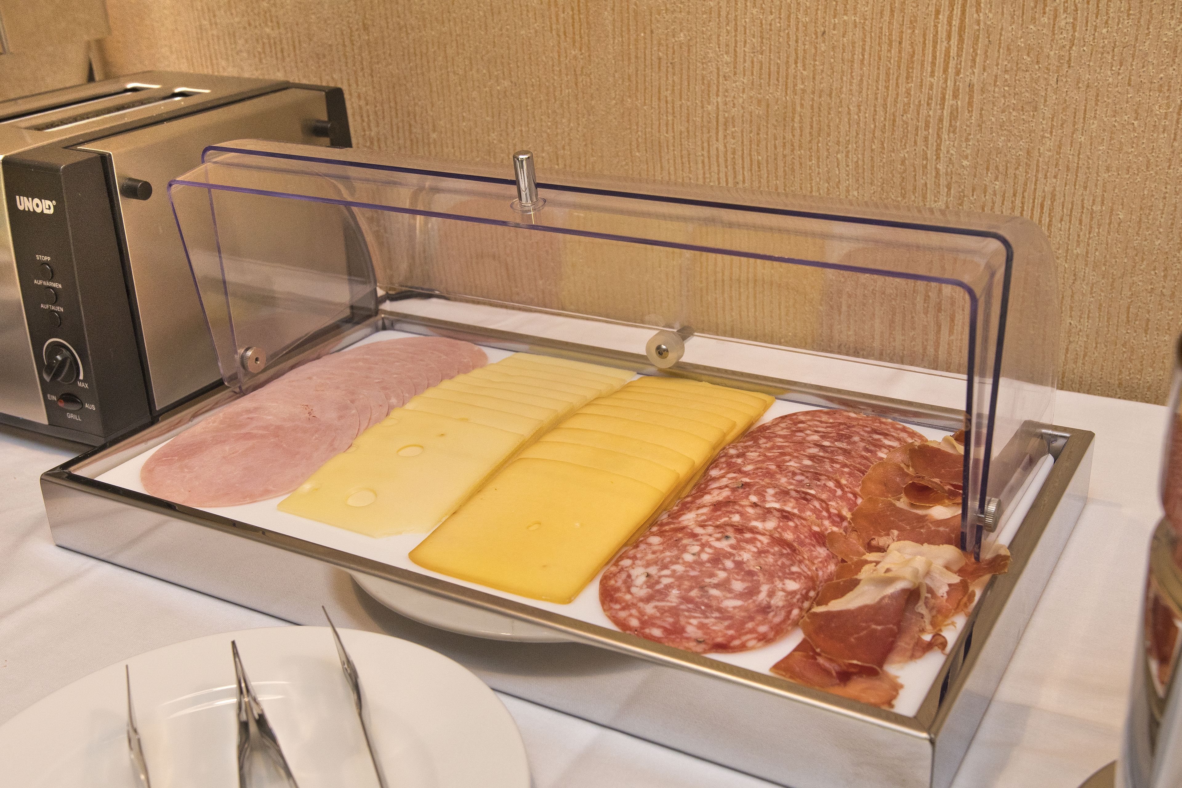A buffet with various meats and cheeses.