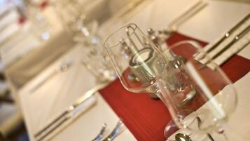 A table set with clear glassware, silverware, and a red napkin.