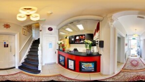 A hotel lobby with a reception desk, a staircase, and a hallway leading to other rooms. - Revado Hotel, Norwich City Centre (Norwich)