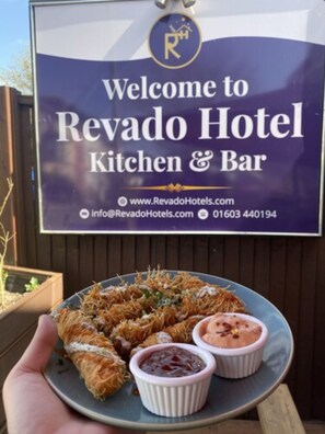 A sign for Revado Hotel Kitchen & Bar with contact information and a plate of food. - Revado Hotel, Norwich City Centre (Norwich)