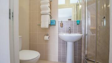 Un baño con inodoro, lavabo y ducha.