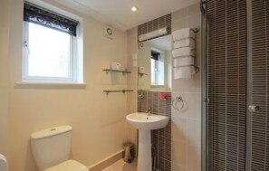A bathroom with a toilet, sink, and shower area. - Revado Hotel, Norwich City Centre (Norwich)