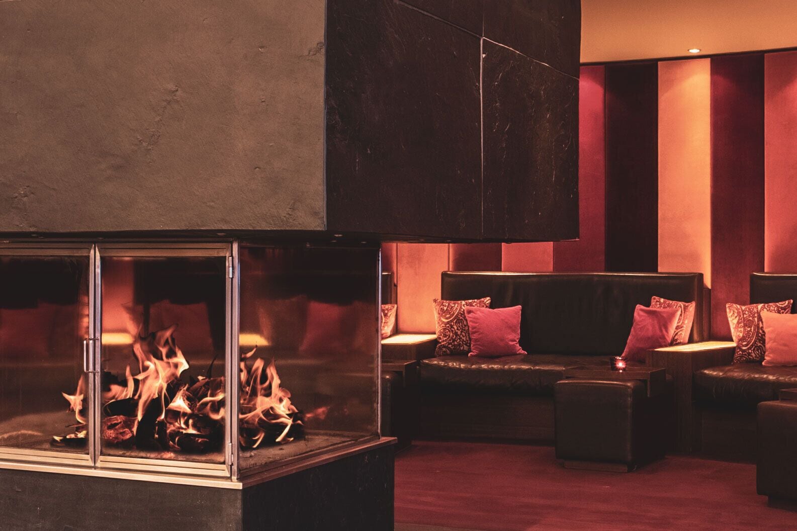 A modern interior with a fireplace, leather seating, and a large mirror.