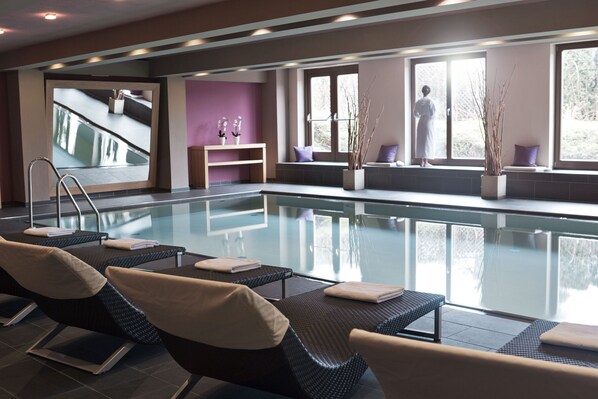 A spa area with a pool, reclining chairs, a mirror, and a view of the outdoors. - POP-UP LIVING Zell am See (Zell am See)