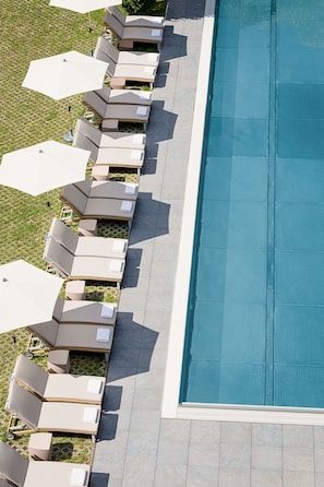 An aerial view of a swimming pool area with lounge chairs and umbrellas. - POP-UP LIVING Zell am See (Zell am See)