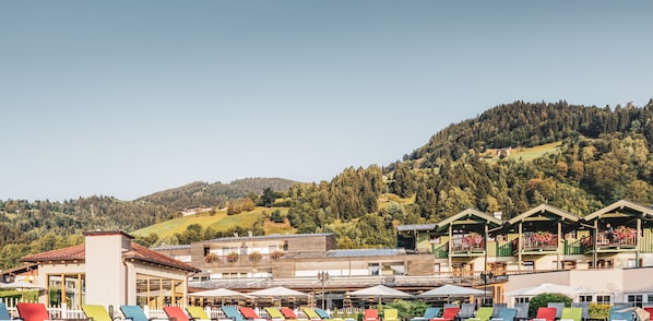 Un hĂŽtel dotĂ© dâune terrasse extĂ©rieure aux couleurs vives, avec une vue sur les montagnes et une architecture traditionnelle.