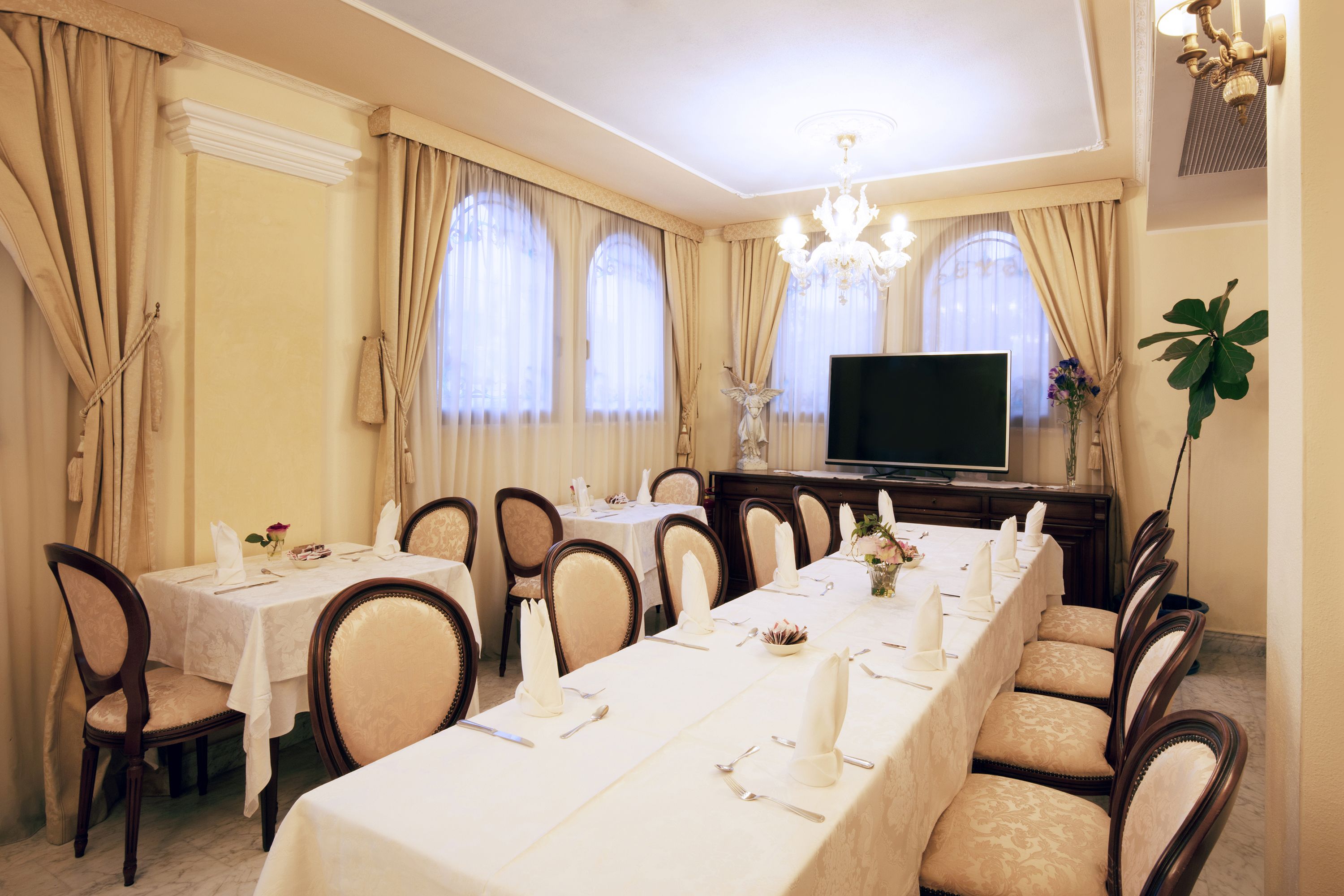 Ein Esszimmer mit einem langen Tisch, gedeckt für eine Mahlzeit, umgeben von Stühlen.