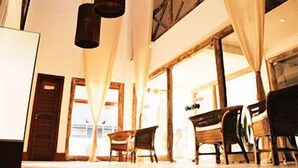 A modern interior with a high ceiling, large windows, and a staircase leading to an upper level. - Maritima Flat (Natal)