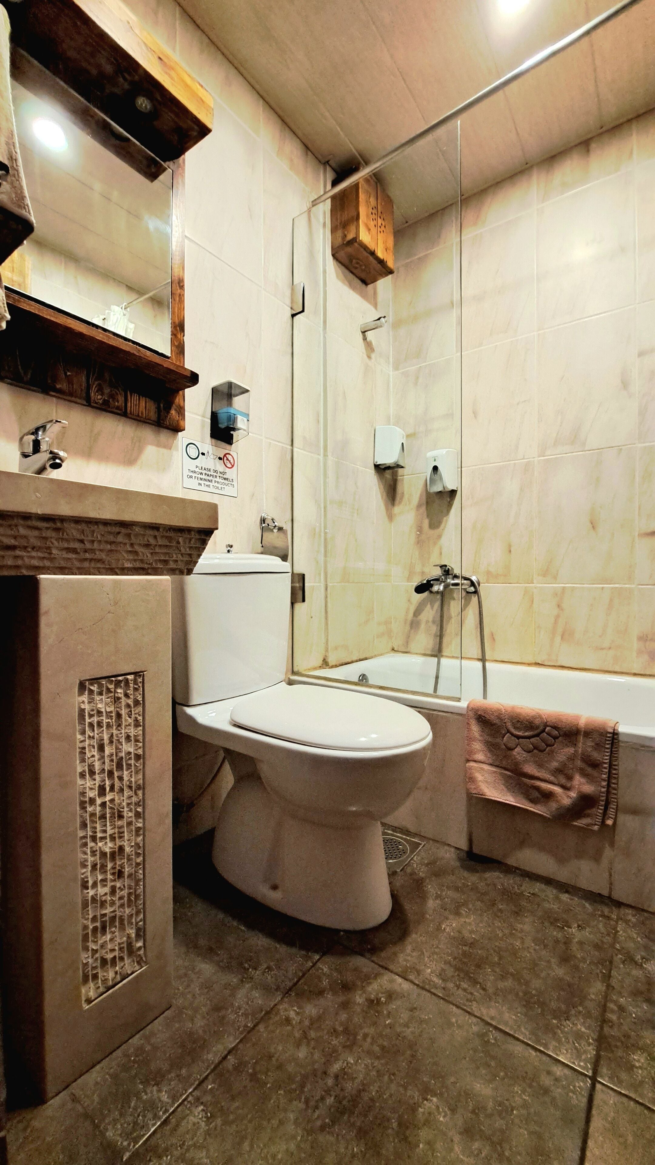 Une salle de bain comprenant des toilettes, un lavabo et un espace douche.