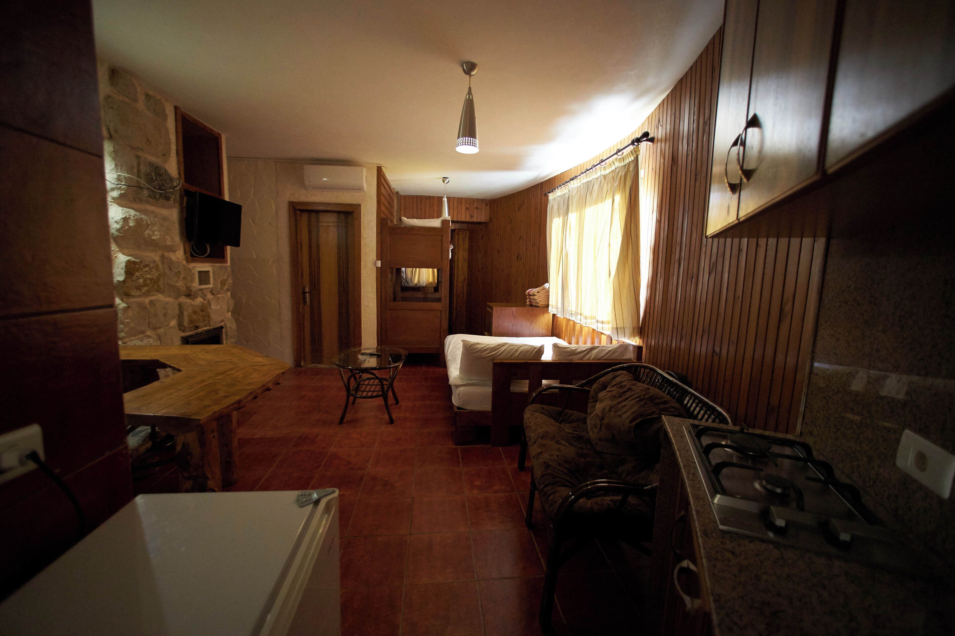 A compact kitchen with a stove, a dining table, and a built-in bench.