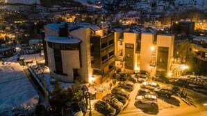 A hotel with a parking lot, surrounded by snow-covered hills. - Faraya Village Club (Faraya)