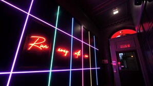 A neon-lit corridor with a sign reading "Run away with it." - Revolver Edinburgh (Edinburgh)