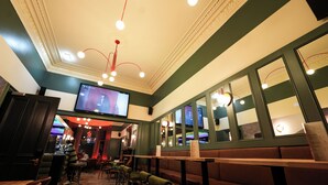 A restaurant interior with booths, high-top tables, and bar stools. - Revolver Edinburgh (Edinburgh)
