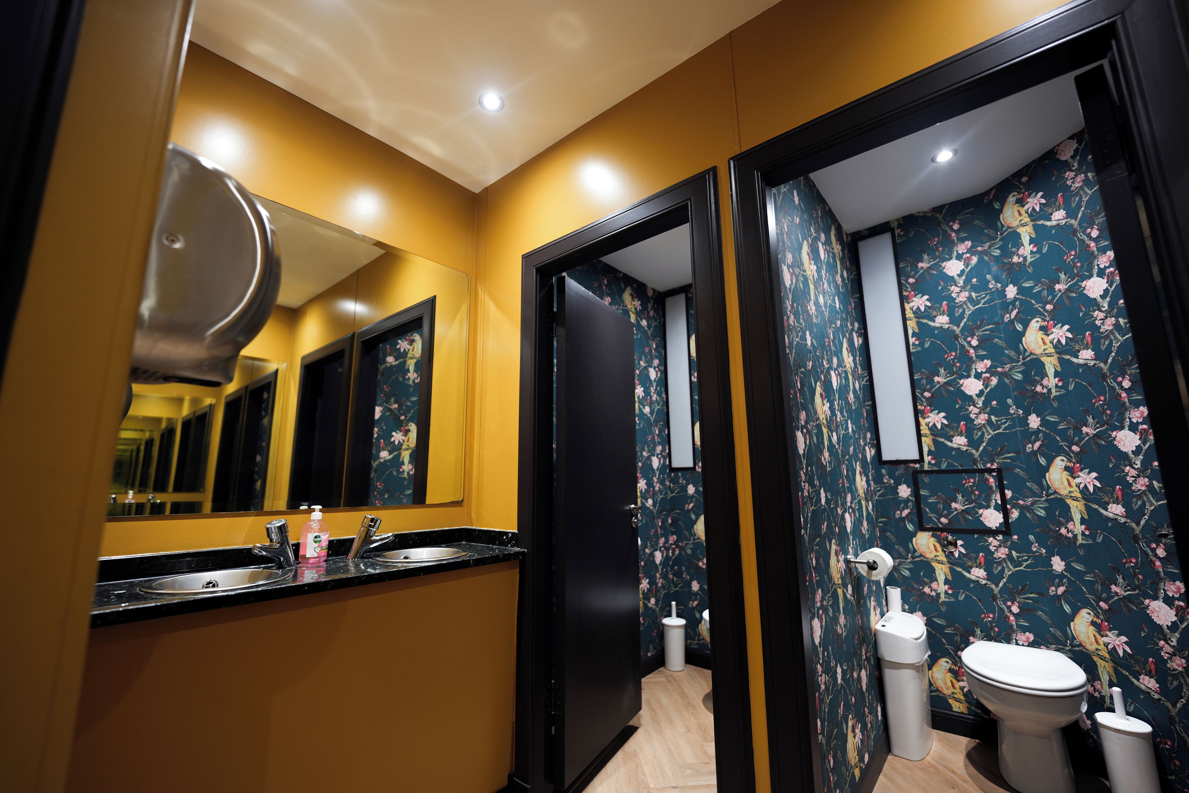 Un bagno con lavandino, specchio, toilette e zona doccia.