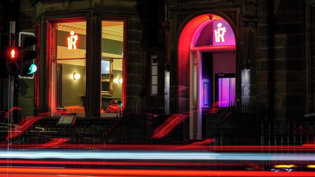 A building with two illuminated entrances, one with a 'R' sign and another with a 'P' sign, suggesting restrooms. - Revolver Edinburgh (Edinburgh)