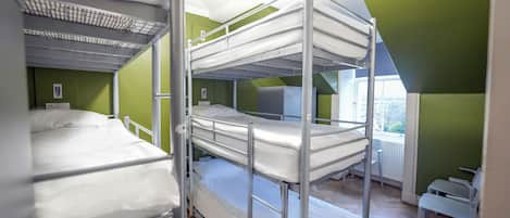 A bunk bed room with green walls and a window.