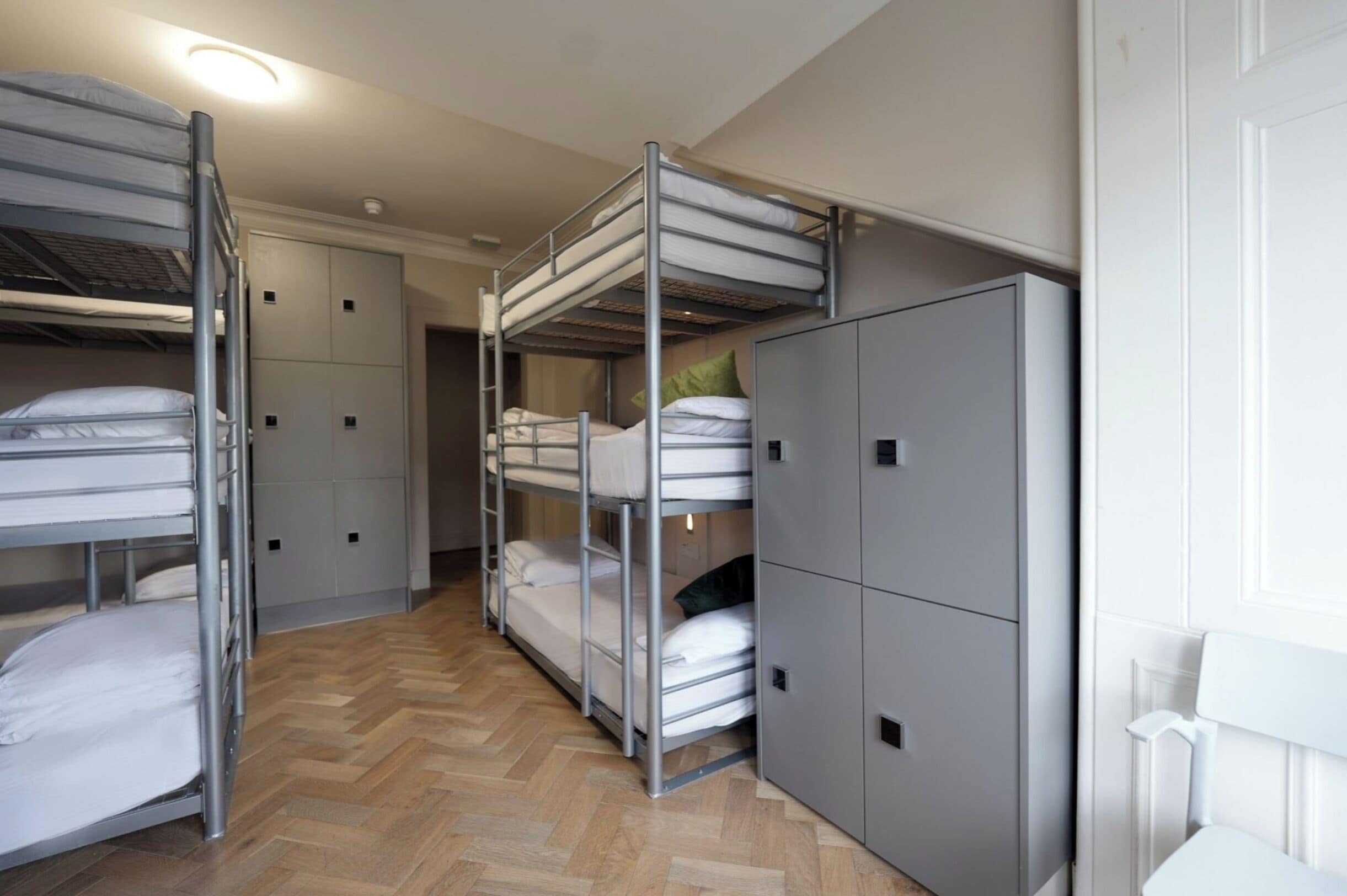 A bunk room with two bunk beds, a wardrobe, and a radiator.