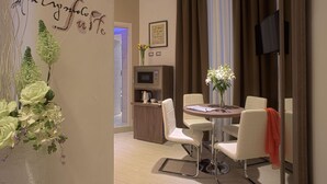 Een moderne eetruimte met een ronde tafel, witte stoelen en een bloevas.