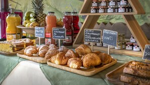 Un bufé de desayuno con pasteles, frutas y salsas.