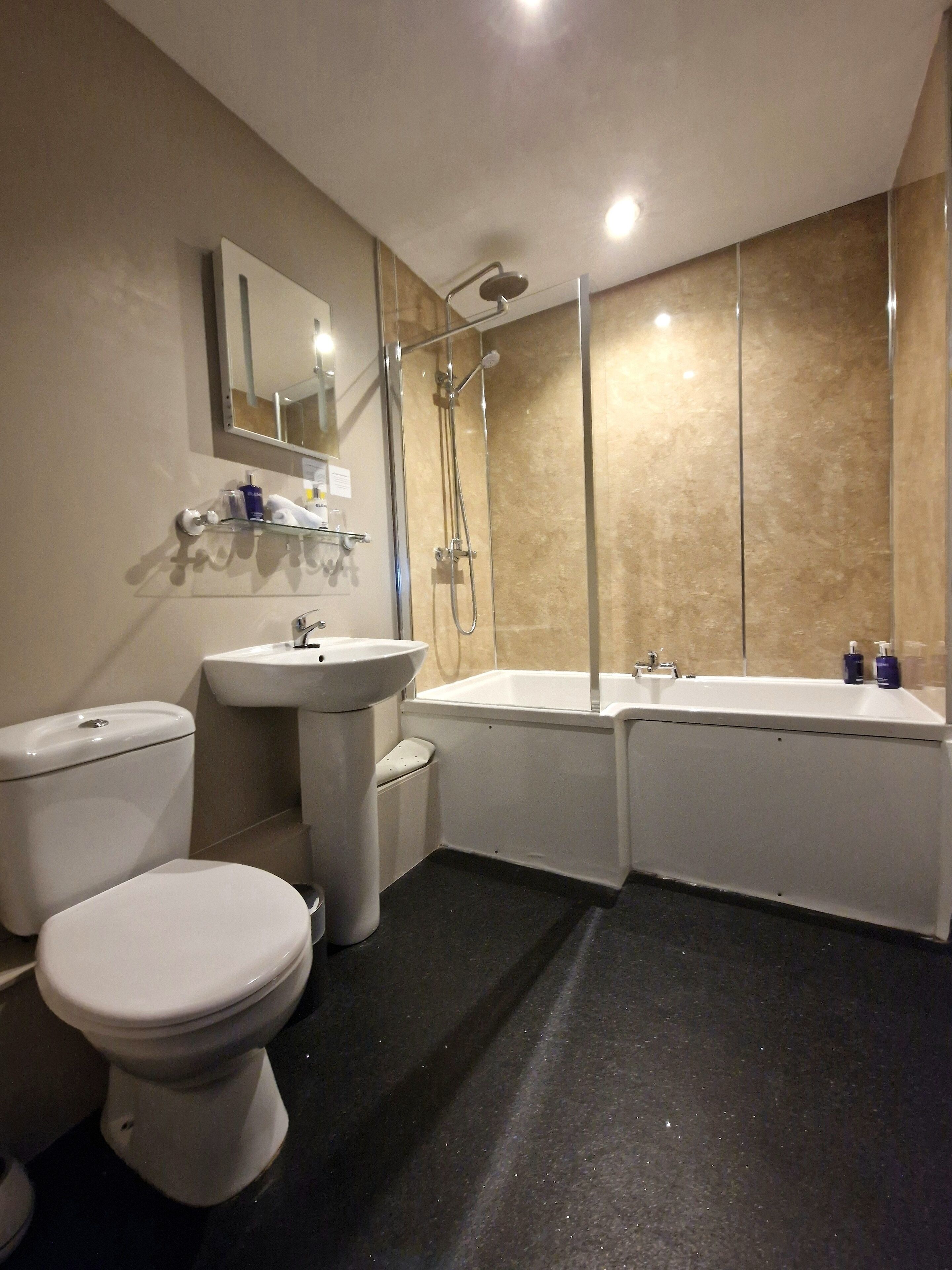 A modern bathroom with a toilet, sink, and bathtub.