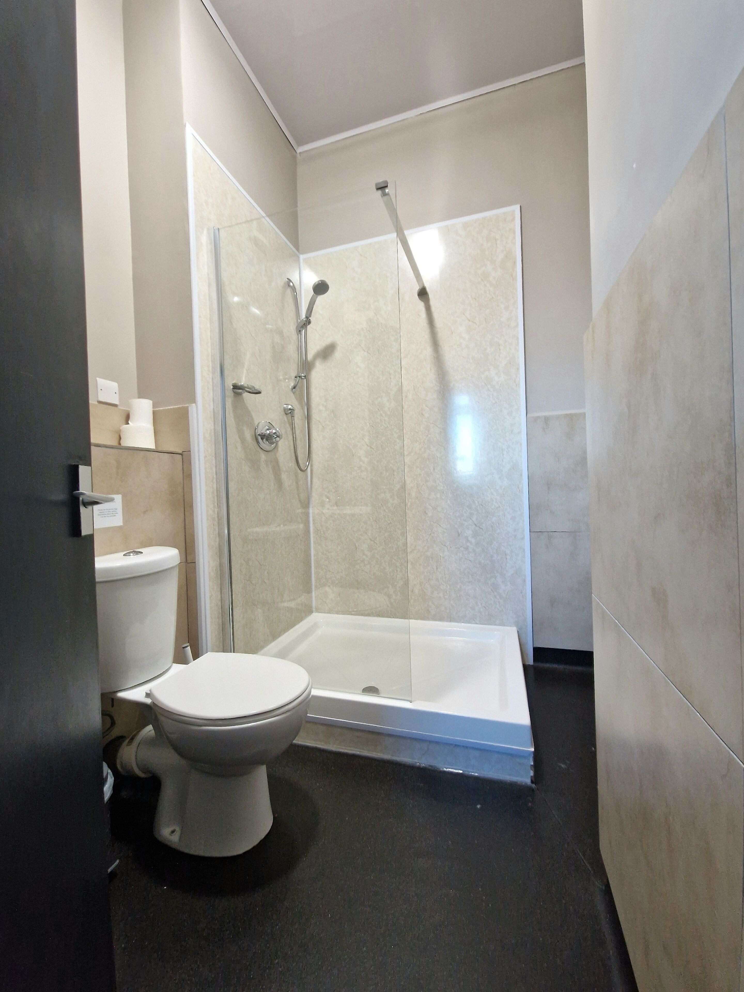 A modern bathroom with a toilet, a glass-enclosed shower, and a bathtub.