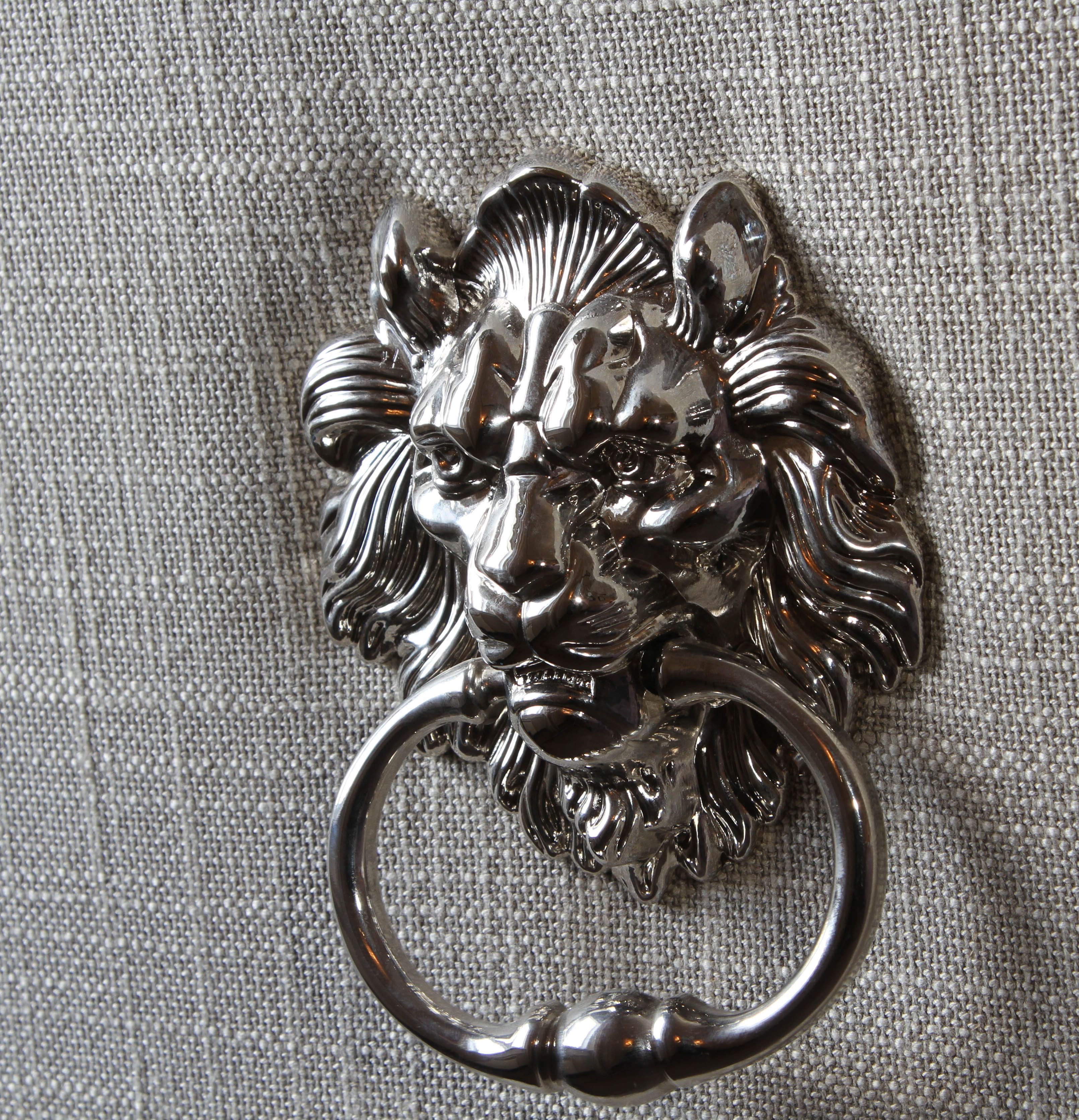 A metal keychain with a lion's head design.