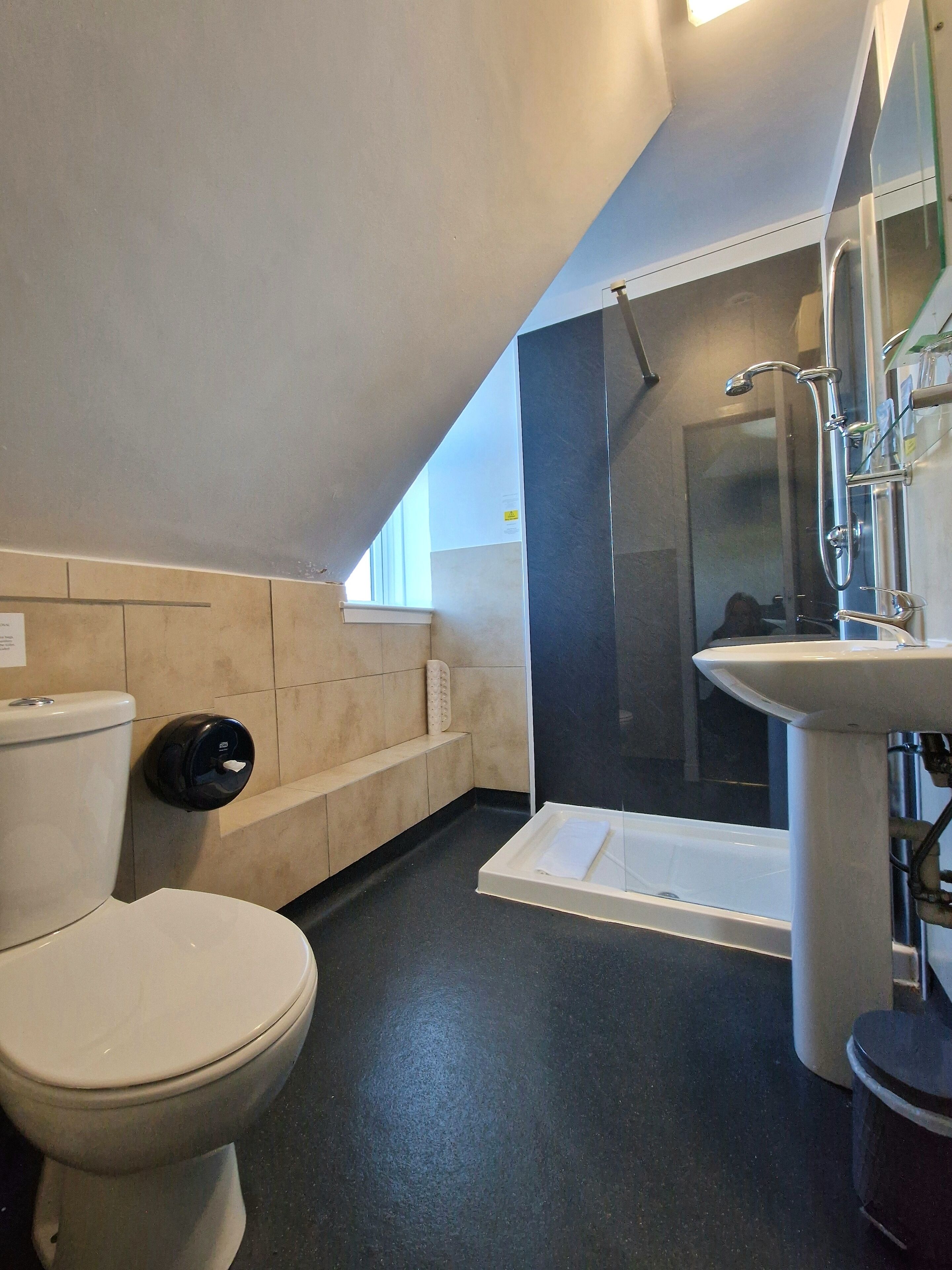 A modern bathroom with a toilet, a bidet, a sink, and a shower.