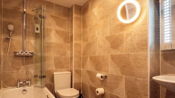 Un baño moderno con ducha de vidrio, inodoro y lavamanos.