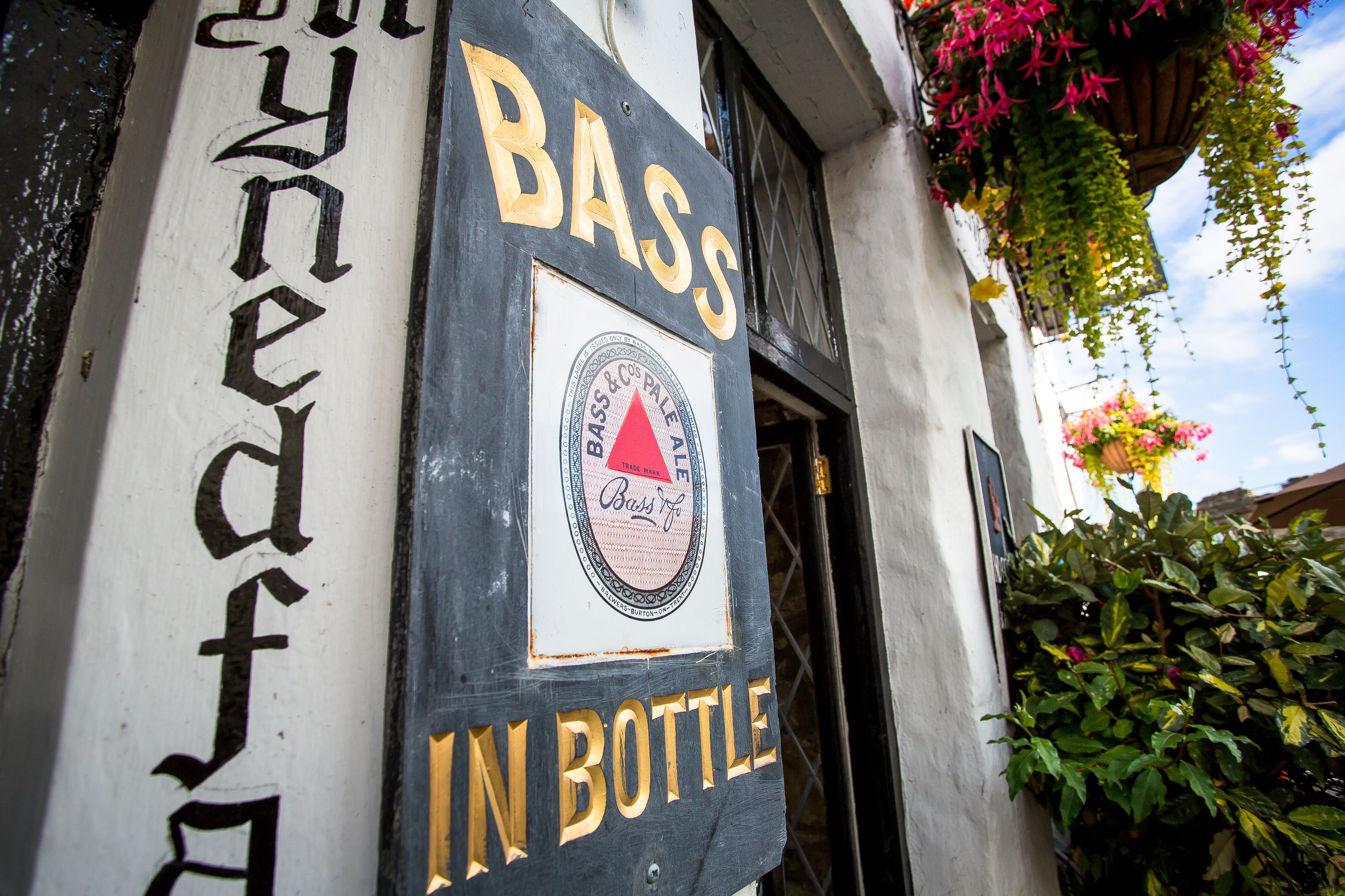 A sign with the text "BASS IN BOTTLE" and a logo.