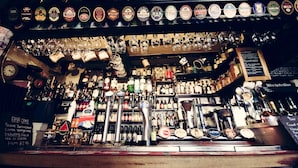 A bar with various bottles, glasses, and a menu.